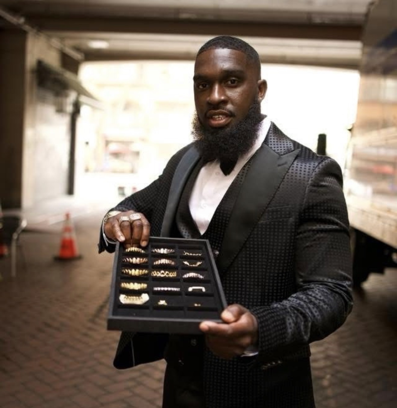 The jeweler holding a display tray of gold grillz